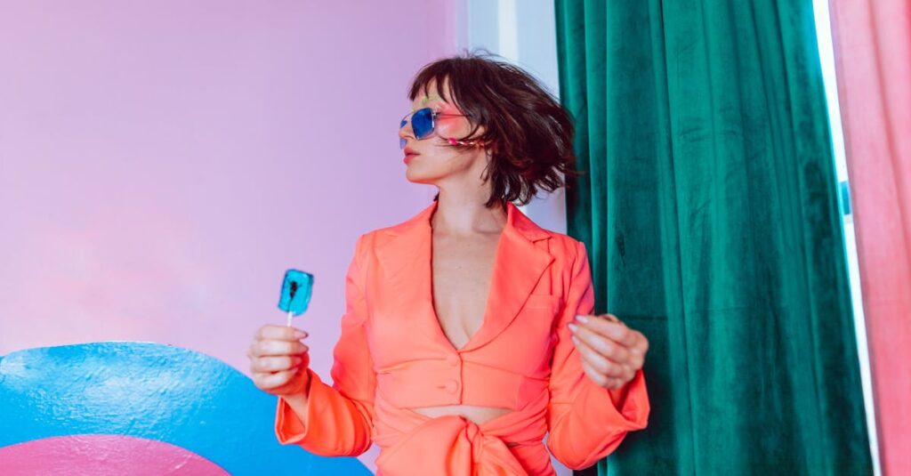 pexels-photo-7035238-7035238 Trendy portrait featuring a woman in vibrant attire with sunglasses holding a blue lollipop.